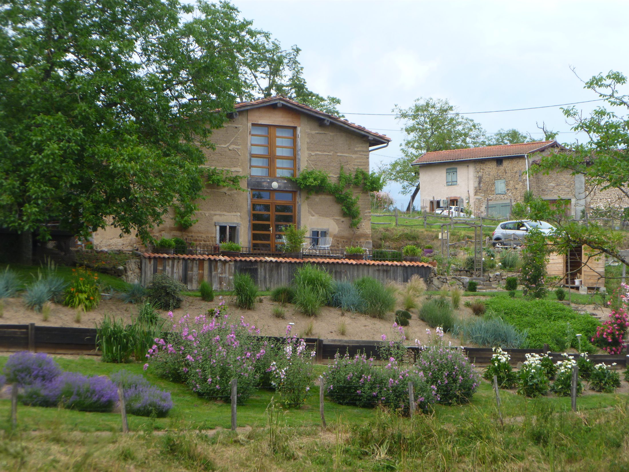 Vue du gîte et du jardin paysager