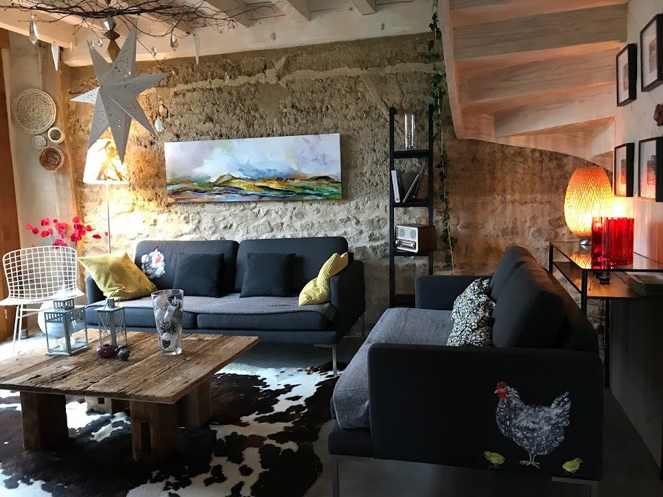 Salon avec mur en pierre et décoration contemporaine